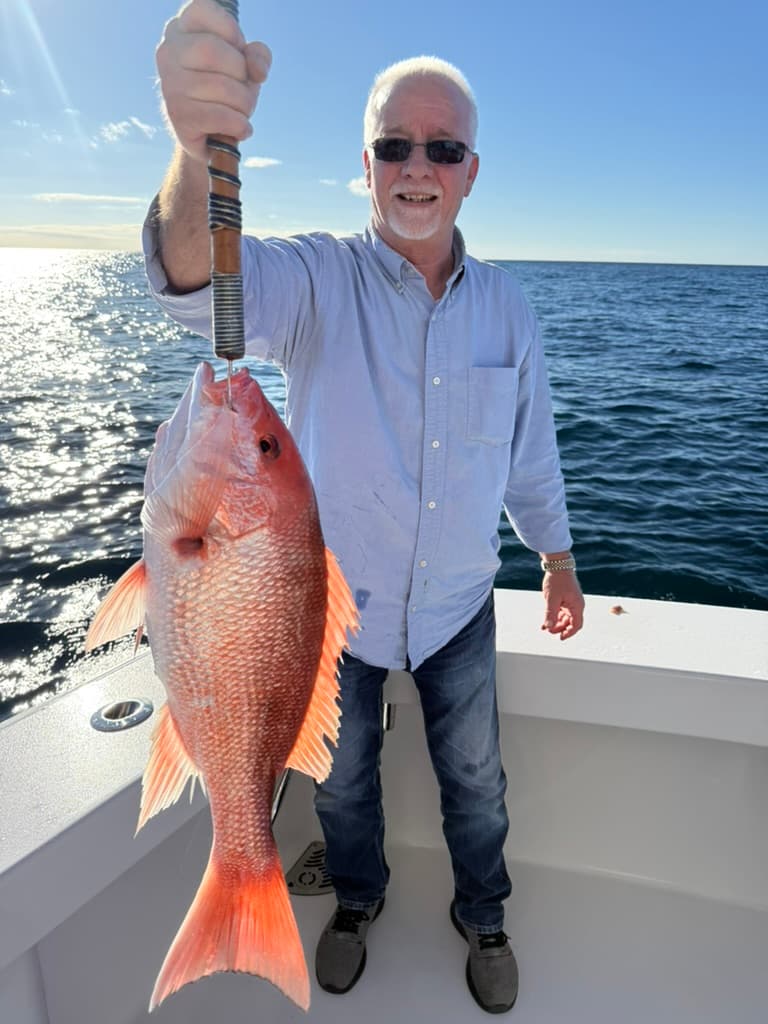 Angler with a red snapper, sunset light across the Gulf